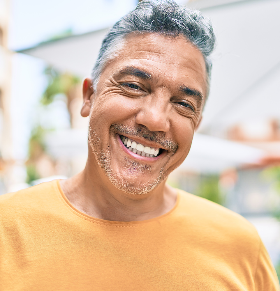 mid-aged man in orange shirt smiling